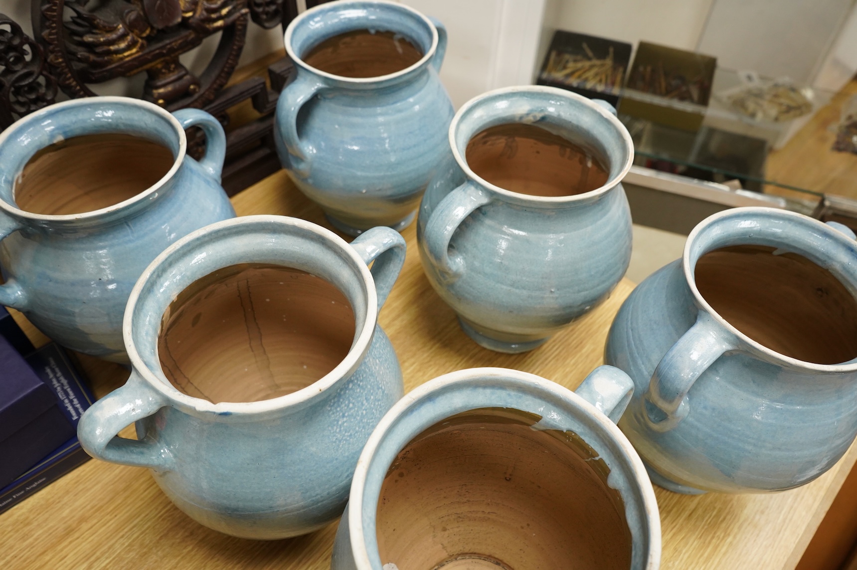 Seven early 20th century Continental blue glazed terracotta twin handled jars, 26cm high